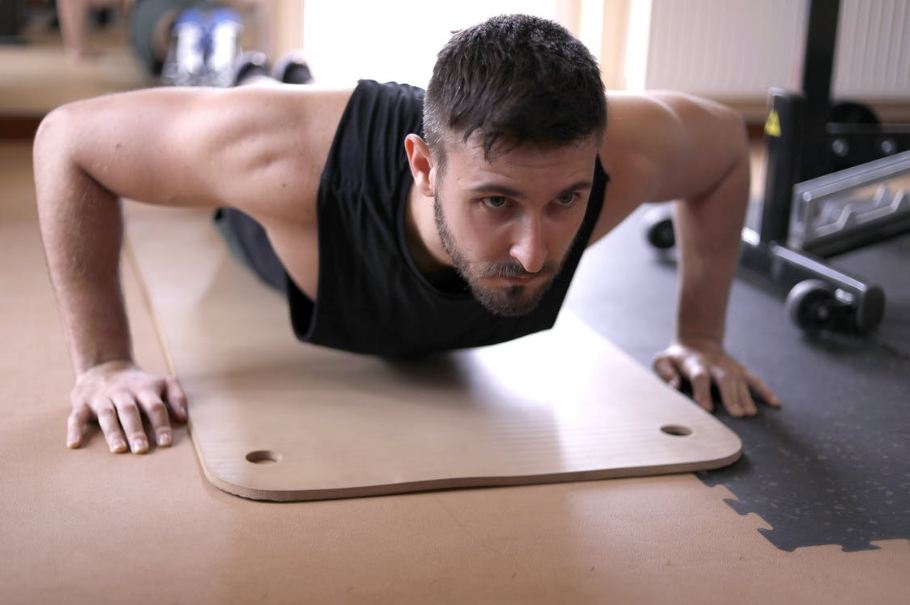 man-in-k-black-tank-top-doing-push-ups