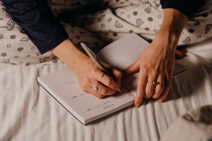 A person writing on a journal