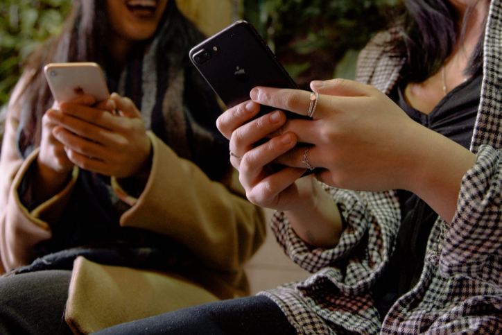 Two women using their phones