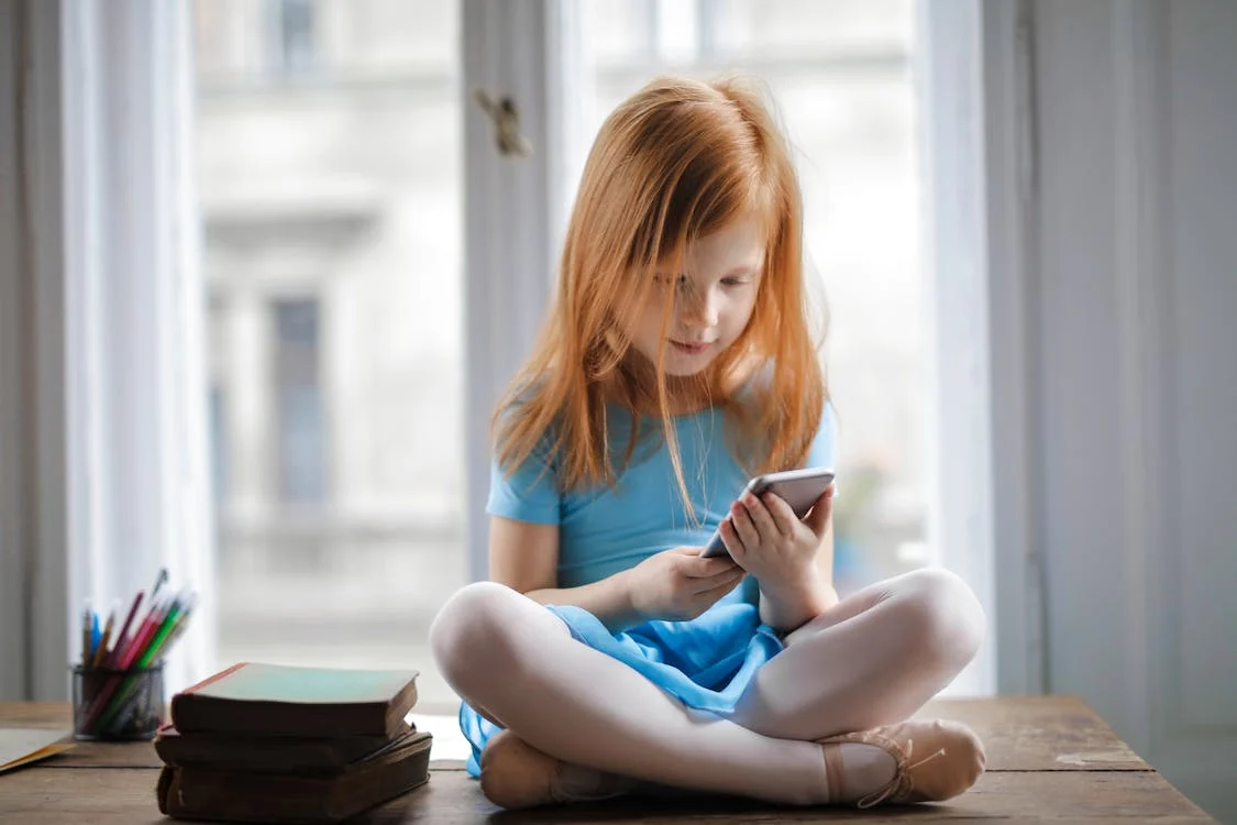 Getting-a-phone-for-your-kid-Smiling-kid-with-a-phone