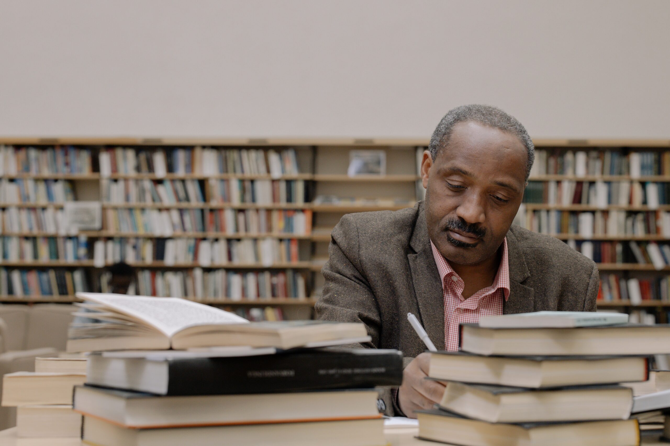 man-reading-books-in-library